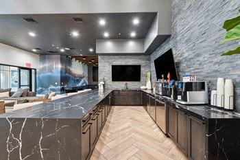 A modern kitchen with a marble countertop and wooden cabinets. at The Laurel Apartments, Arizona, 85286